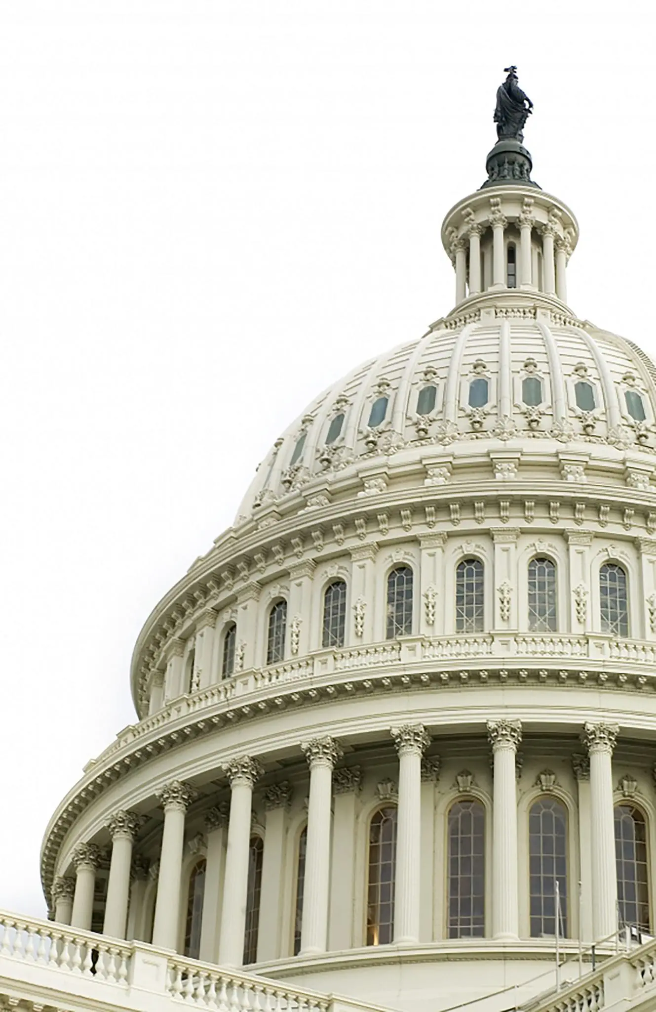 A close-up view of the United States Capitol dome under a cloudy sky.