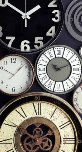 A collection of variously styled analogue clocks with different designs and numbers fills the frame.