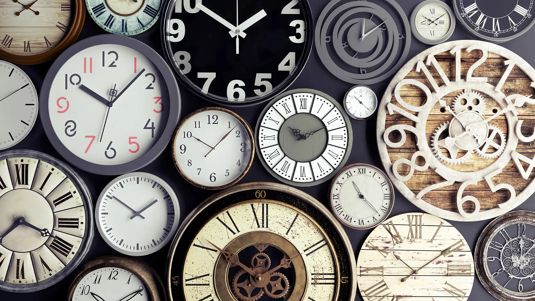 A collection of variously styled analogue clocks with different designs and numbers fills the frame.