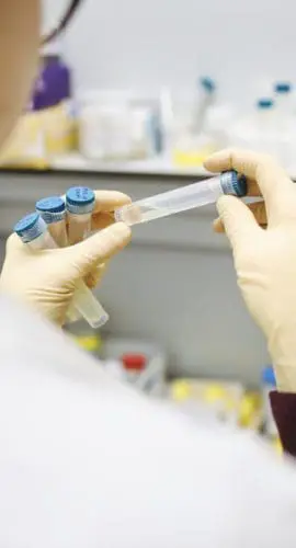 Person holding test tubes