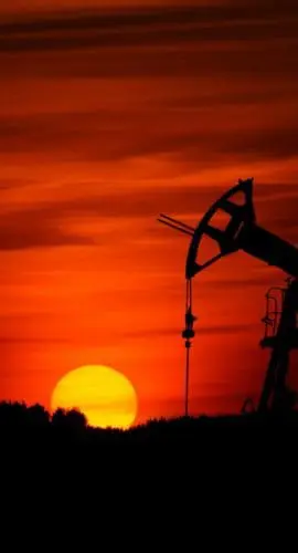 Pump-jack mining crude oil with the sunset