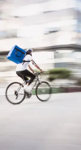 Food and supplies delivery man in motion blur. He is rushing on a destination in a downtown district. Belgrade, Serbia