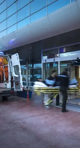 Paramedics taking patient on stretcher from ambulance to hospital