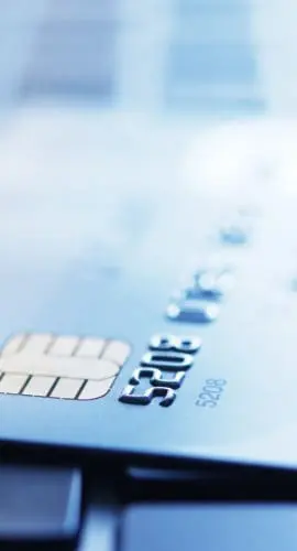 Blue tinted image of credit card on laptop with shallow depth of field.