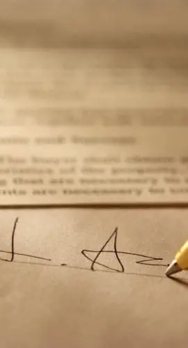 Sepia toned Image of signing a contract with shallow depth of field.