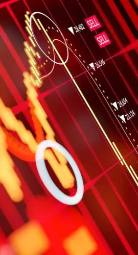 A glowing red digital trading screen displaying cryptocurrency candlestick charts, sell signals, and falling price data, illustrating Bitcoin market volatility and the risks of crypto investing in a turbulent digital assets landscape.