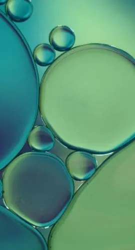 Close-up macro photograph of oil and water droplets suspended together, illustrating the chemical complexity of produced water and the challenges of separation, treatment, and reuse.